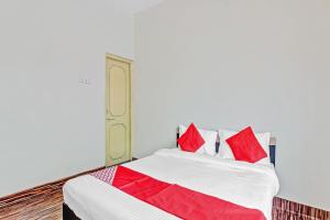 ChikalthānOYO Shree Balaji Lodging的一间卧室配有红色枕头的床
