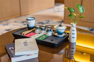 济南润华世纪酒店(济南西站国际会展中心店)的一张桌子,上面有带筷子和花瓶的托盘