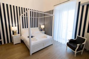 巴里Le residenze del capitano的卧室配有白色的天蓬床和椅子