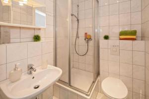 塞巴特阿尔贝克Pension Haus Antje的带淋浴、盥洗盆和卫生间的浴室