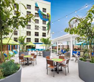 圣地亚哥Margaritaville Hotel San Diego Gaslamp Quarter的一座配有桌椅的庭院和一座建筑