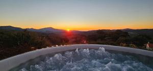 马拉加Casa KiSi Cottage, Rural Boutique Bed & Breakfast的享有日落美景的热水浴池