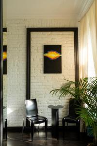 第比利斯Unfound Door - Design Hotel的一间设有两把椅子、一张桌子和一面墙的房间
