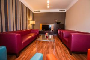 特尔纳瓦伊恩帕库酒店的客厅配有2张红色沙发和电视