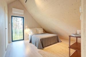 赫尔辛基Villa Pickala - Design - Seafront - Hot tub的阁楼上的卧室设有一张床,设有窗户