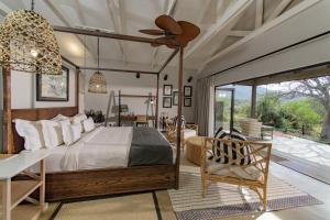 丹地Valley Lodge - Babanango Game Reserve的卧室配有一张床和一张桌子及椅子