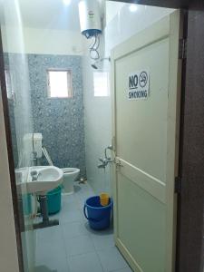 达波林Sai Leela Guest House的浴室设有卫生间水槽和禁烟标志。