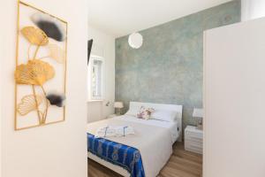 圣伊西多罗Villino delle Orchidee by BarbarHouse的卧室配有白色的床和蓝色的墙壁