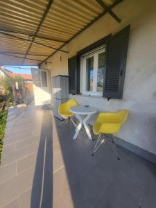 韦尔切利Casa Veronica的庭院配有2把黄色椅子和桌子