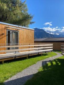因特拉肯Unique Tiny Eco Lodges with gorgeous views to Jungfrau Massiv的一座木结构建筑,在草地上设有长椅