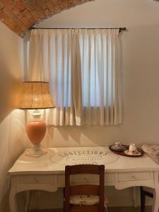 比戈尼奥Grotto Flora B&B Chambres de charme的一张带台灯的桌子和一张带窗户的桌子