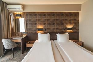 索佐波尔Kalithea Family Hotel的一间卧室配有一张大床、一张桌子和两个枕头