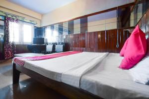 西姆拉OYO Flagship Hotel Unique的卧室配有一张带粉红色枕头的大床