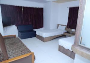 JālgaonHotel Kewal INN Jalgaon的酒店客房设有两张床和窗户。