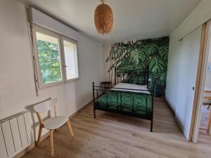 Saint-AndréLa Source, location saisonnière proche Cognac的一间卧室配有绿色的床和椅子