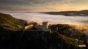 比哈奇Hotel GOLD JET Bihać的山顶上一层云的城堡