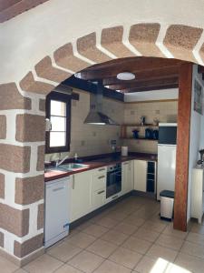 阿索马达Casa Bena的带砖墙的厨房和带白色家电的厨房