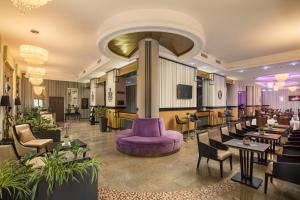 毛科毛科荣耀格兰德酒店的酒店大堂设有紫色的沙发和桌椅