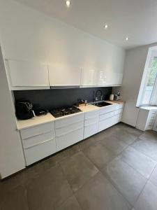 凯尔克拉Luxurious House in Kerkrade Center的白色的厨房配有白色橱柜和水槽