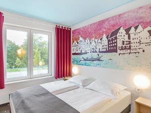 吕讷堡鲁纳堡B＆B酒店的卧室配有一张床,墙上挂有绘画作品