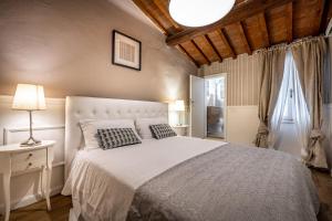 佛罗伦萨Florentine Experience in Santa Croce的一间卧室配有一张带白色床罩的大床