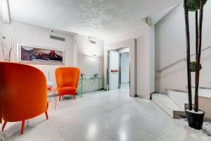 罗马贝斯特韦斯特电影音乐酒店的客厅配有橙色椅子和桌子