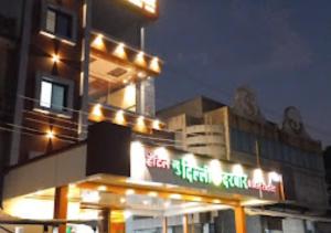 JālgaonHotel New Delhi darbar family restaurant Jalgaon的一座晚上有灯的建筑