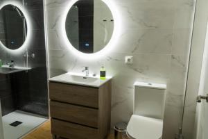 马德里Rooms Luxury Madrid的一间带水槽、卫生间和镜子的浴室