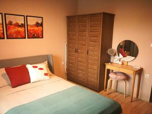 卡赞勒克Kalina Apartment Kazanlak的一间卧室配有一张床和一张带镜子的桌子
