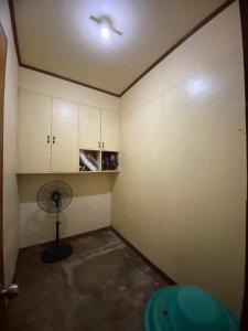 马比尼Perucho-Silang Guest House的客房设有带风扇和橱柜的客房。