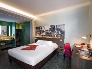里昂Greet Hotel Lyon Confluence的酒店客房设有一张大床和一张书桌。
