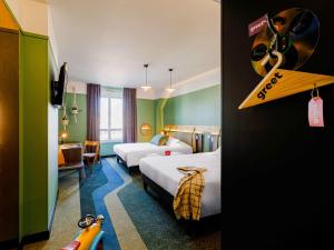 里昂Greet Hotel Lyon Confluence的酒店客房配有两张床和一张书桌,而一间客房则设有