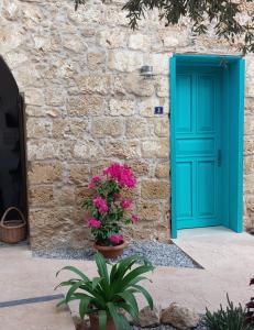 法马古斯塔Bella Casetta Guest House的石头建筑的一边,花朵 ⁇ 的蓝色门