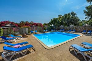 维琪奥港Camping U Pirellu的一个带蓝色躺椅的游泳池,一个度假胜地