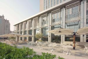 迪拜迪拜市中心罗弗酒店的大楼前带桌子和遮阳伞的天井