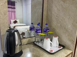巴拉特布尔Hotel Kavya Inn的酒店客房带镜子和水瓶