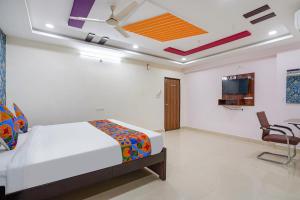 海得拉巴FabHotel Sri Karthikeya Grand的一间卧室配有一张床和吊扇
