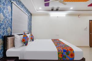 海得拉巴FabHotel Sri Karthikeya Grand的卧室配有白色床和蓝色的墙壁