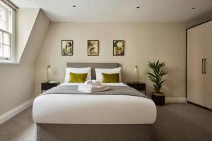 伦敦Chancery Lane by Viridian Apartments的卧室配有一张带黄色枕头的大型白色床。