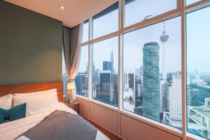 吉隆坡Calm Sojourn, Sky Suites KLCC的一间卧室设有大窗户,享有城市景观