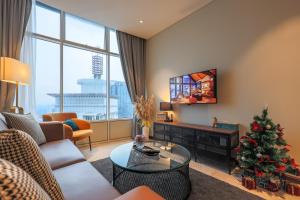 吉隆坡Calm Sojourn, Sky Suites KLCC的客厅配有圣诞树和电视