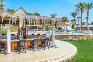 沙姆沙伊赫Jaz Fayrouz的度假村的酒吧,带椅子和游泳池