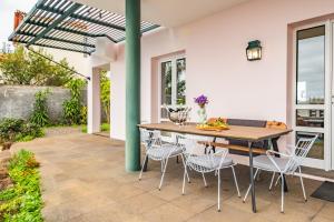 丰沙尔Villa Magnólia的庭院配有木桌和椅子