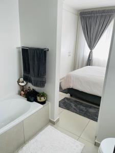 SandtonApollo one bedroom的白色的浴室设有床和浴缸。