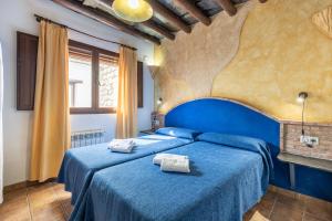 贝尔楚勒斯Turismo Rural & SPA El Cercado的一间卧室配有两张蓝色床单