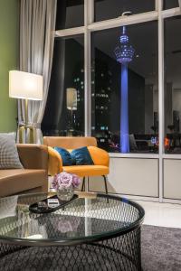 吉隆坡Calm Sojourn, Sky Suites KLCC的带沙发和玻璃桌的客厅