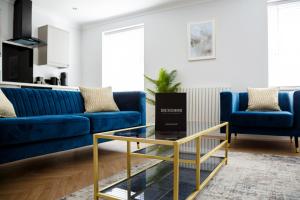 斯卡伯勒The Salisbury - Luxury Apartments by Stay In Scarborough的客厅配有蓝色的沙发和玻璃桌