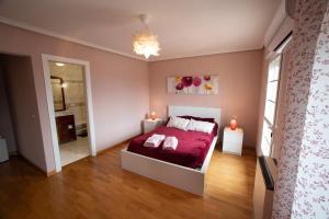 哈兰迪雅·德·拉·维尔CASA DOVELA的一间卧室配有一张带红色床单的床和两盏灯。