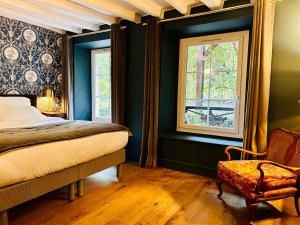 DampierreL’Auberge du Château的一间卧室设有绿色的墙壁、一张床和椅子