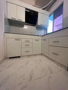 勒克瑙Metro Nook的厨房配有白色橱柜和微波炉